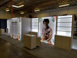 Custom Inline Exhibit with Extensive Shelving, Backlighting Including Backlit Graphics, Locking Storage, Full Closet, and Reception Counters