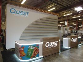 Custom Island Exhibit with Custom Counters, LED Perimeter Lighting and Logos, Locking Storage, Product Shelves, and Reception Counter