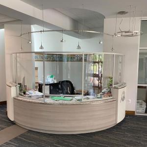 Curved Acrylic and Engineered Aluminum Safety Barrier for an Elegant Reception Desk
