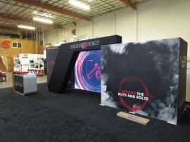 Custom Inline Exhibit with SEG and Pillowcase Fabric Graphics, Backlit Lightbox, Closet Storage, Large Monitor Mount, and MOD-1540 Reception Counter with Locking Storage